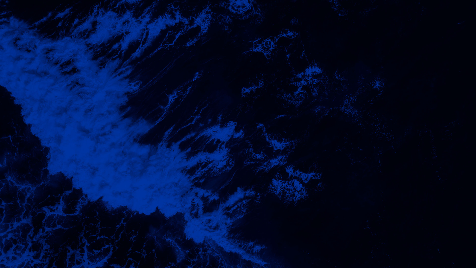 Vista aérea de ondas no mar em tons de azul profundo